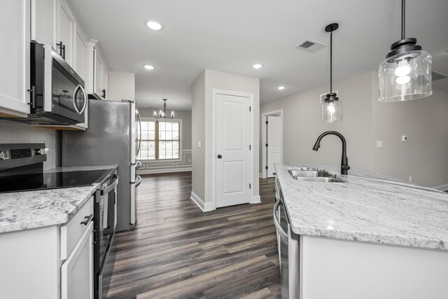 kitchen featuring pendant lighting, sink, a kitchen island with sink, stainless steel appliances, and white cabinets