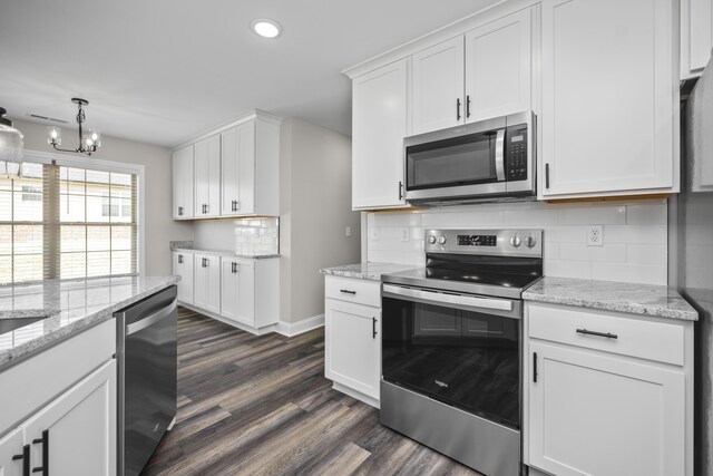 kitchen featuring appliances with stainless steel finishes, dark hardwood / wood-style floors, white cabinetry, decorative backsplash, and light stone countertops