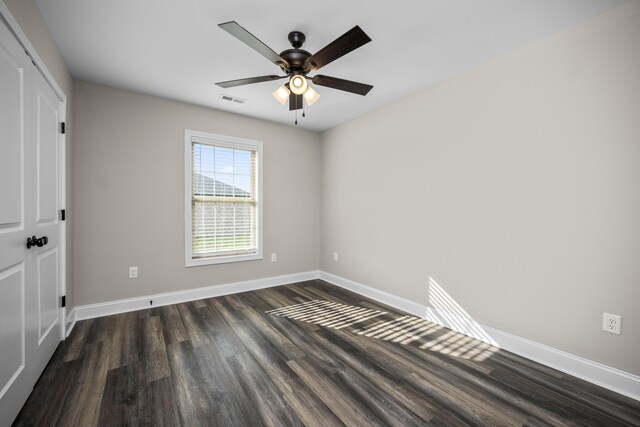 empty room with ceiling fan and dark hardwood / wood-style flooring