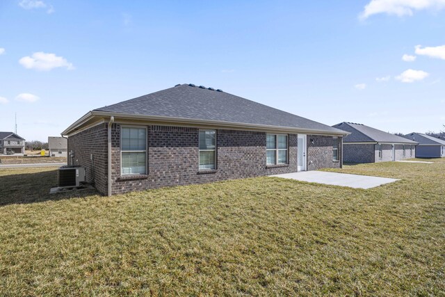 rear view of house featuring a yard, central air condition unit, and a patio area