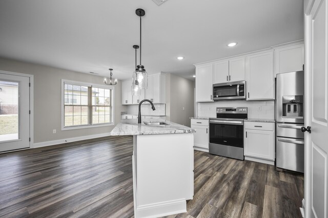 kitchen with stainless steel appliances, hanging light fixtures, sink, and white cabinets