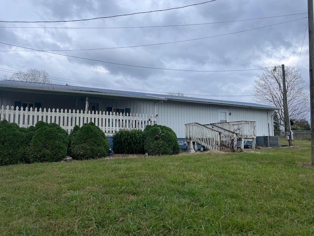 back of property featuring central AC unit and a lawn