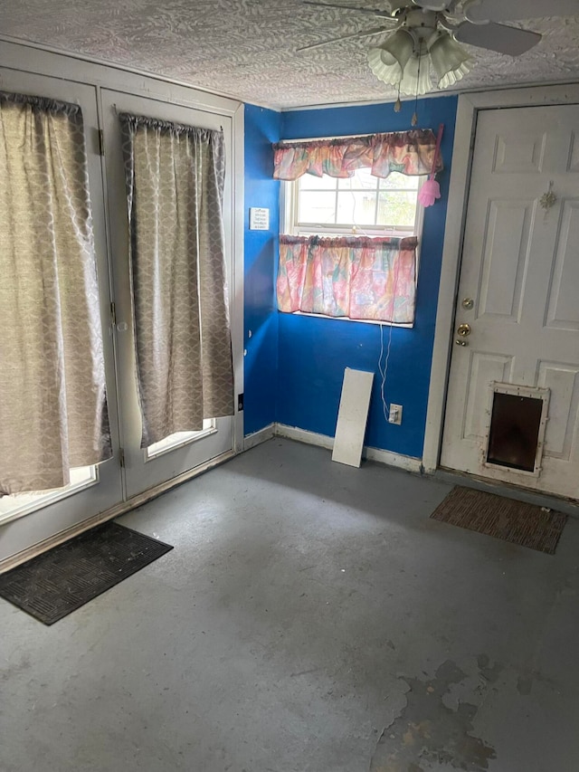 entryway featuring concrete flooring, a textured ceiling, and ceiling fan