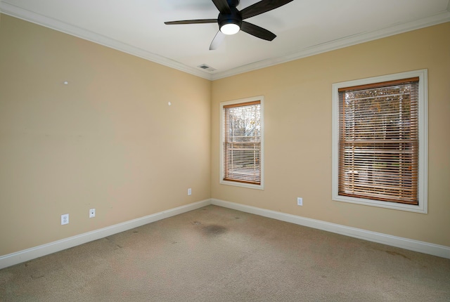 carpeted spare room featuring ceiling fan and crown molding