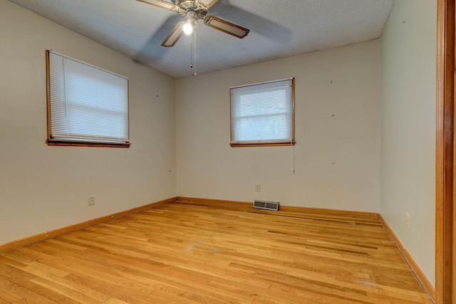 unfurnished room with a textured ceiling, light wood-type flooring, and ceiling fan