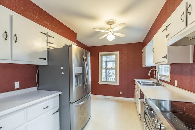 kitchen with white cabinetry, sink, stainless steel appliances, and ceiling fan