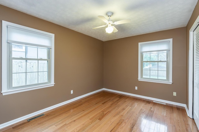 spare room featuring ceiling fan, a textured ceiling, and light wood-type flooring