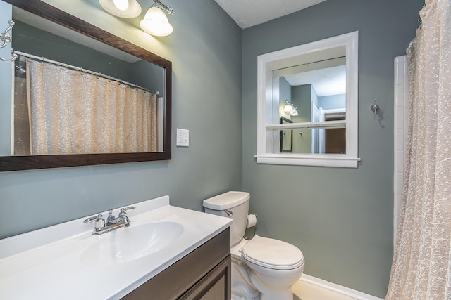 bathroom featuring vanity, curtained shower, and toilet