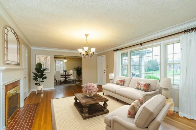 unfurnished living room with hardwood / wood-style flooring, a healthy amount of sunlight, crown molding, and a fireplace