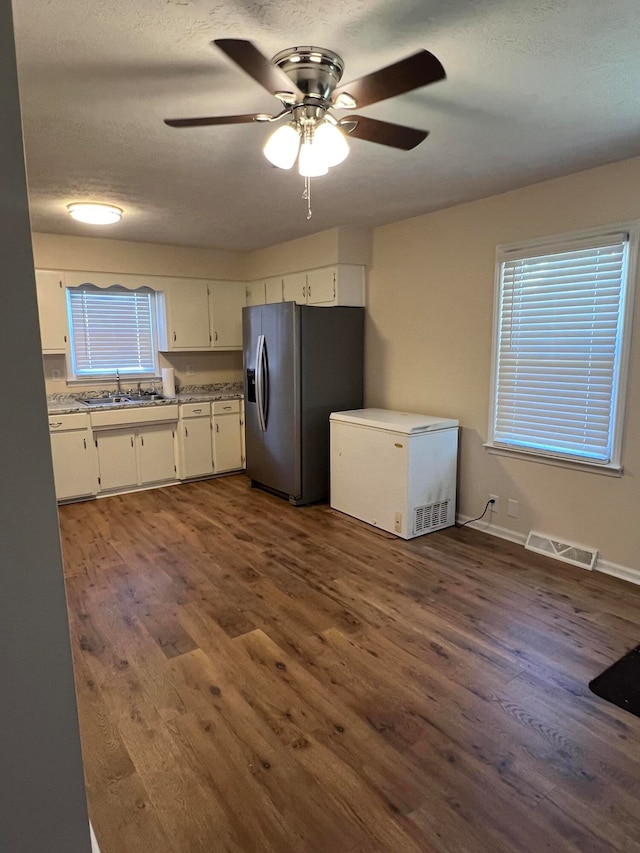 kitchen with white cabinets, stainless steel fridge, dark hardwood / wood-style flooring, and refrigerator