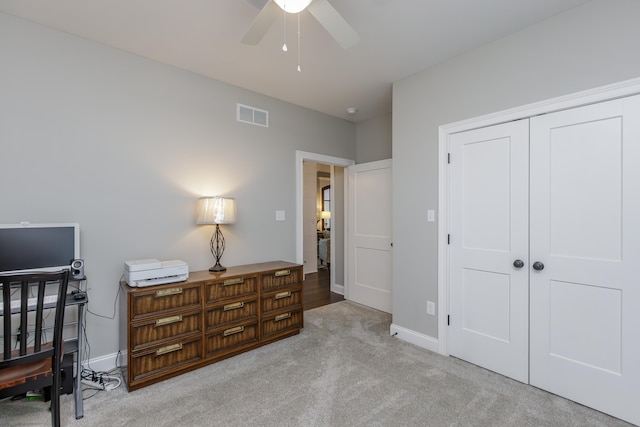 carpeted bedroom featuring ceiling fan and a closet