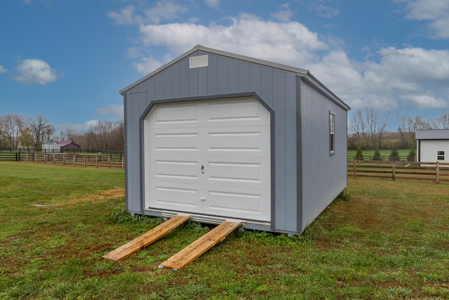 garage with a lawn and a rural view