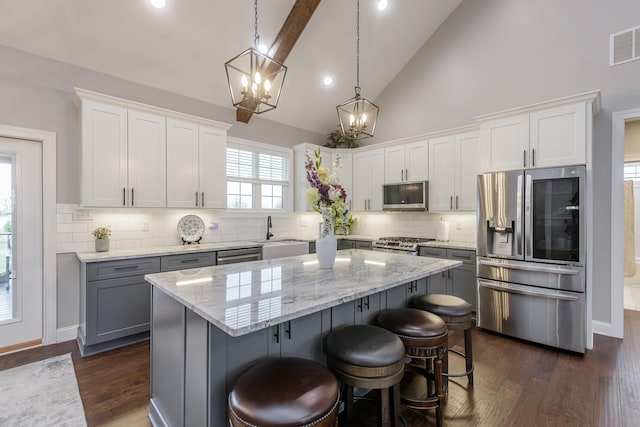 kitchen featuring a center island, white cabinets, dark wood-type flooring, and appliances with stainless steel finishes