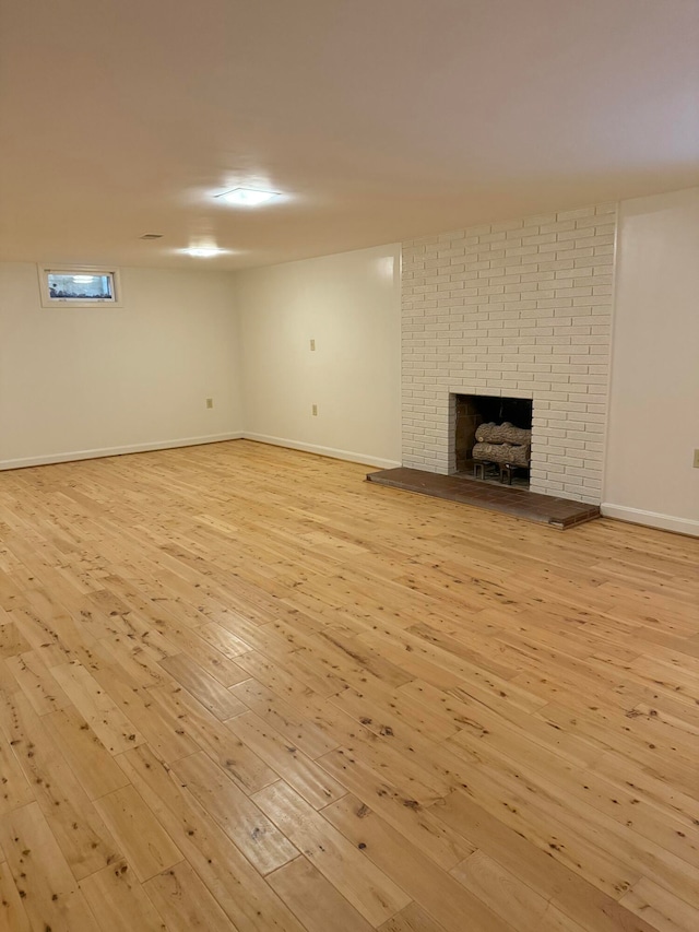 unfurnished living room with light hardwood / wood-style floors and a brick fireplace