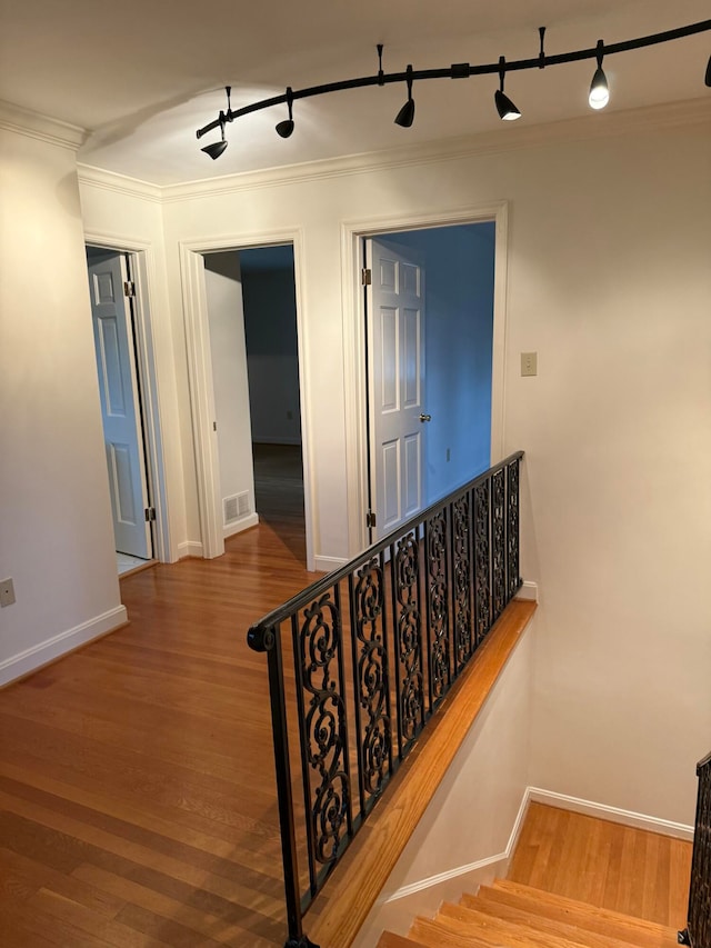 staircase featuring crown molding and hardwood / wood-style flooring