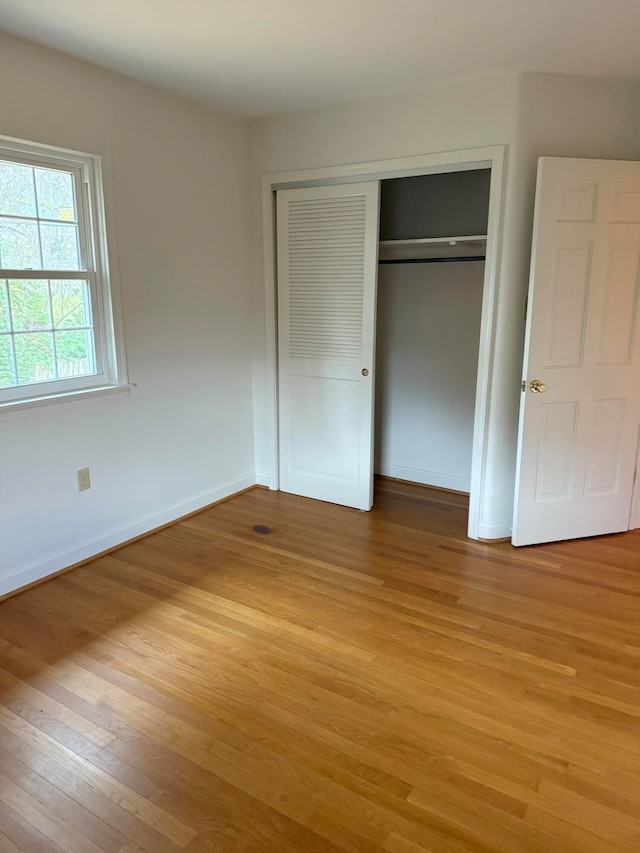 unfurnished bedroom with a closet and light hardwood / wood-style floors