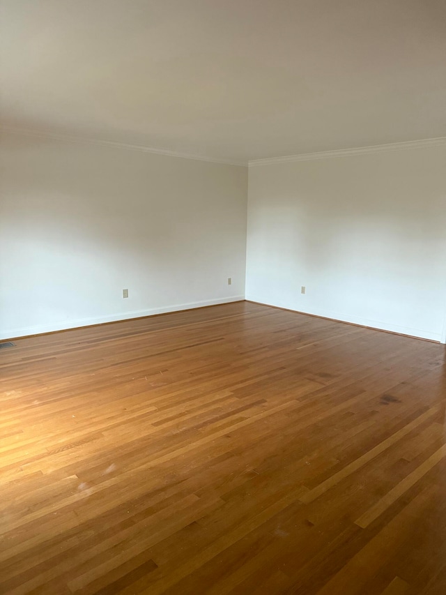 unfurnished room with hardwood / wood-style floors and ornamental molding