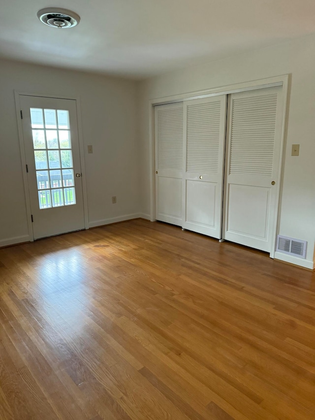 unfurnished bedroom with access to exterior and light wood-type flooring