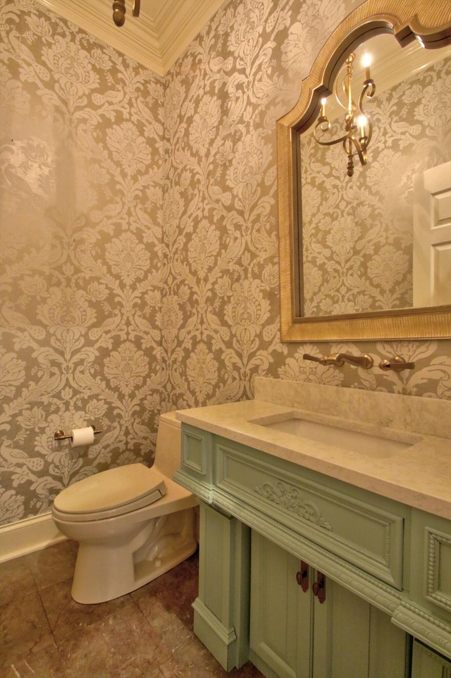 bathroom featuring toilet, vanity, a chandelier, and ornamental molding