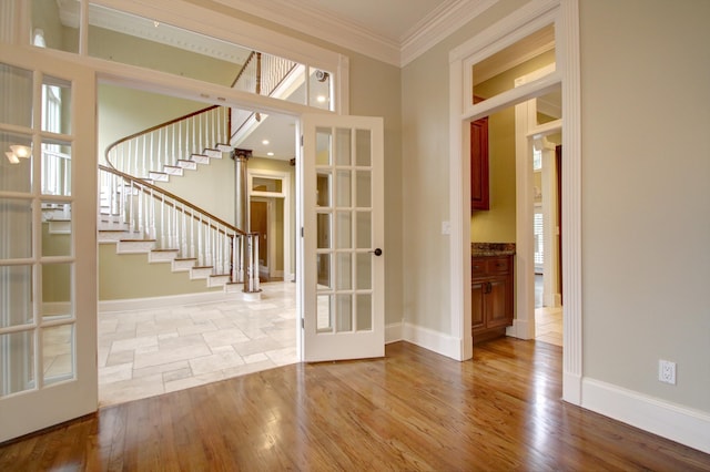 interior space with ornamental molding, french doors, and light wood-type flooring