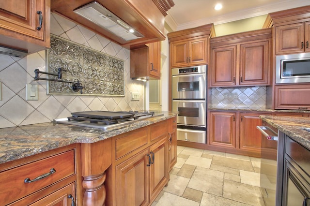 kitchen featuring stainless steel appliances, tasteful backsplash, dark stone countertops, crown molding, and custom exhaust hood