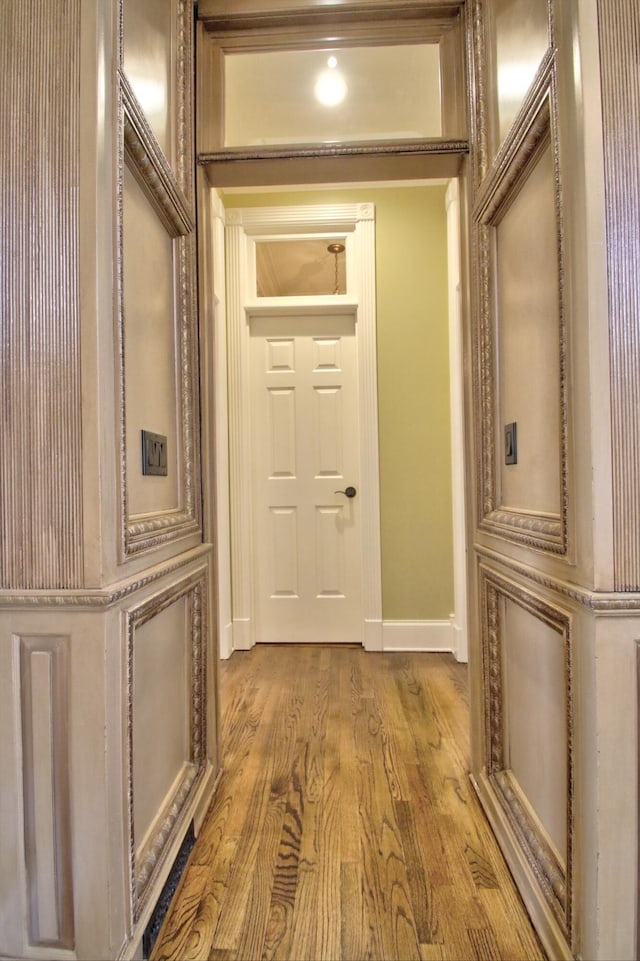 corridor with hardwood / wood-style flooring