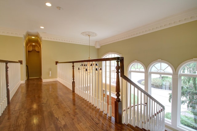 hall featuring dark hardwood / wood-style floors, crown molding, and an inviting chandelier