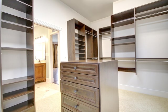 walk in closet with sink and light carpet