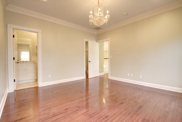 empty room with dark hardwood / wood-style flooring, crown molding, and a chandelier