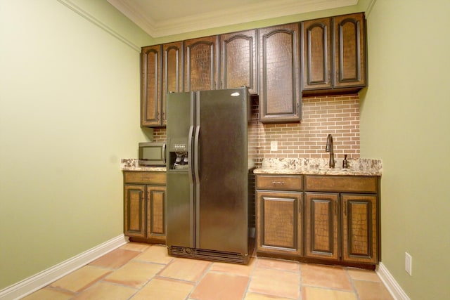 kitchen with sink, light stone counters, backsplash, crown molding, and appliances with stainless steel finishes