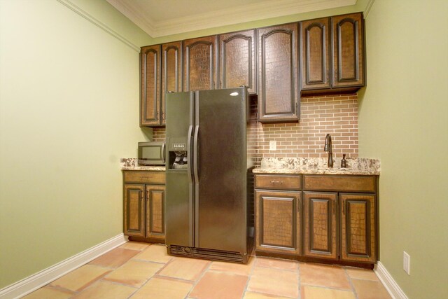 kitchen featuring light tile patterned flooring, sink, ornamental molding, light stone countertops, and black refrigerator with ice dispenser