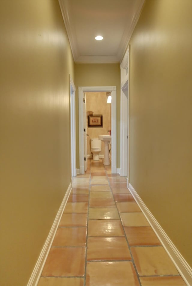 hall with tile patterned floors and ornamental molding