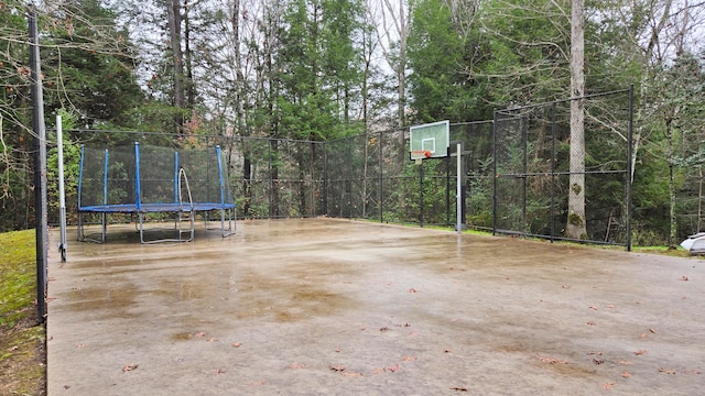 view of patio with a trampoline and basketball hoop