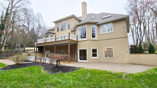 back of house with a lawn, a balcony, and a patio