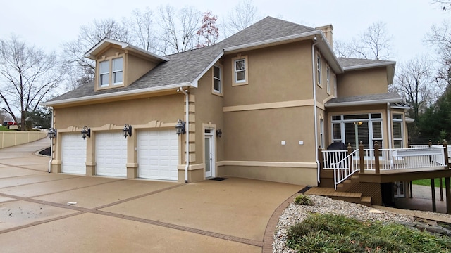 exterior space featuring a garage and a wooden deck