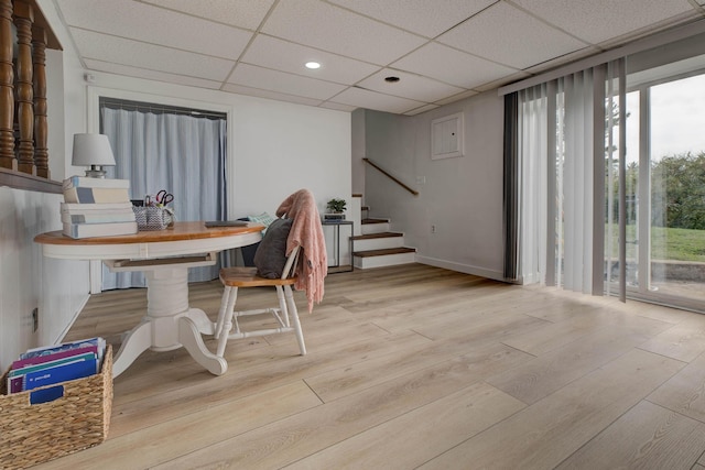 dining space featuring light hardwood / wood-style flooring and a drop ceiling