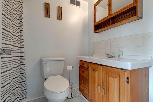 bathroom featuring vanity, toilet, and backsplash