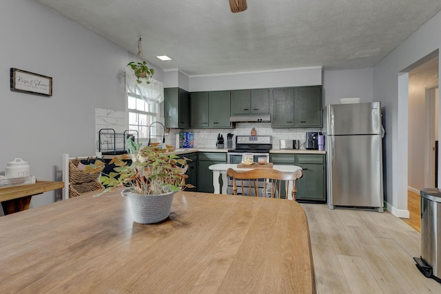 dining area with sink, light wood-type flooring, and a textured ceiling