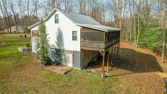 view of side of property with a sunroom and a yard