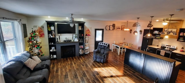 living room featuring dark hardwood / wood-style flooring, ceiling fan, and plenty of natural light