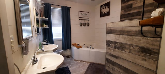 bathroom featuring a tub, sink, and tile patterned flooring