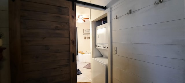 laundry room with stacked washer / dryer and wood walls