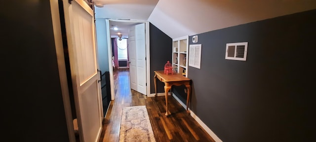 hall featuring dark hardwood / wood-style floors and vaulted ceiling