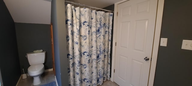 bathroom featuring tile patterned floors, a shower with curtain, and toilet