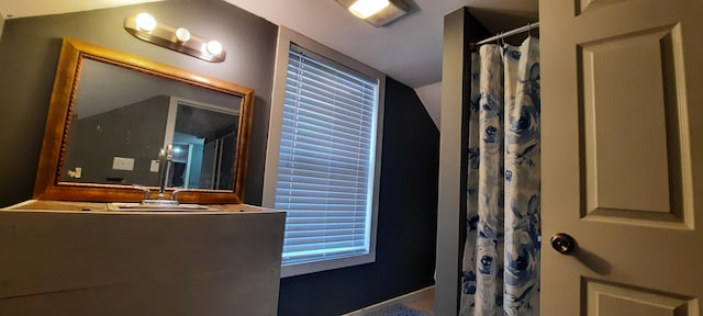 bathroom with curtained shower and sink