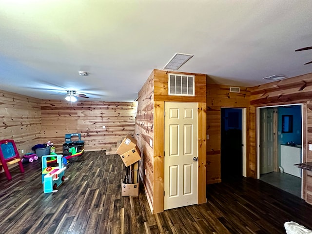 interior space with dark hardwood / wood-style flooring and wood walls