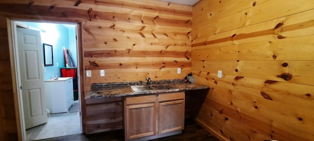 bar featuring wood walls and sink