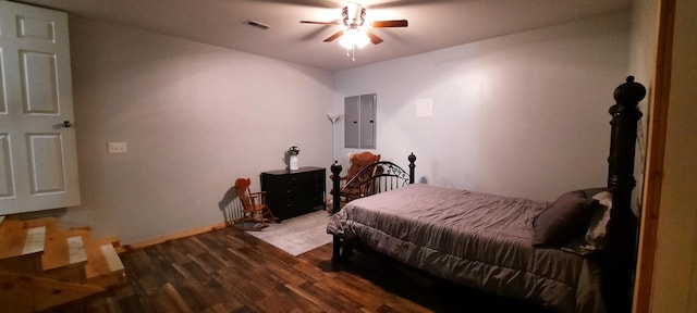 bedroom with electric panel, ceiling fan, and dark hardwood / wood-style flooring