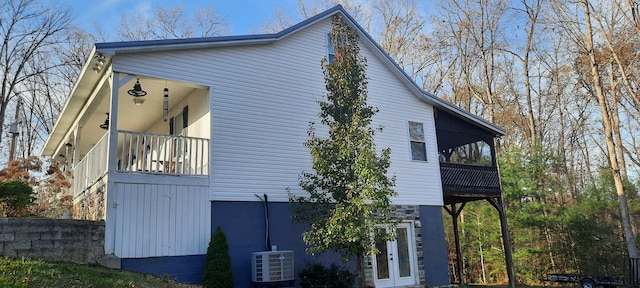 view of property exterior with central air condition unit and a balcony