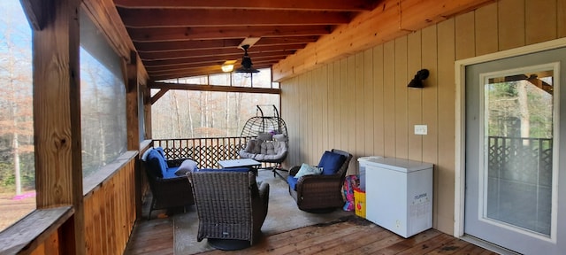 sunroom featuring vaulted ceiling with beams and plenty of natural light